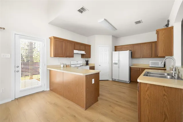 a kitchen with a sink stove top oven and refrigerator