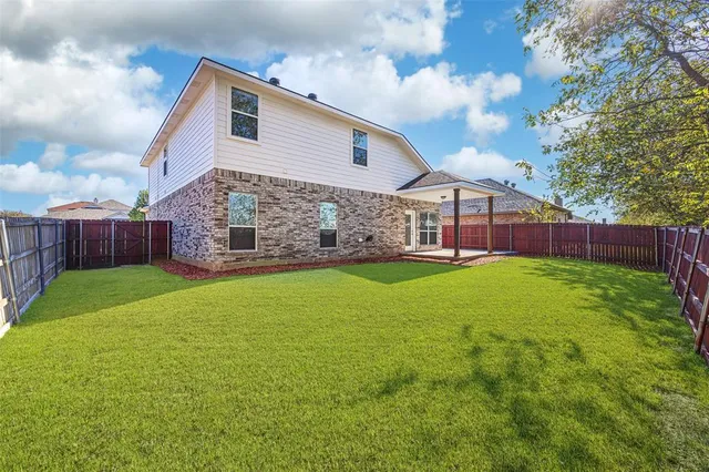 a view of a backyard with wooden fence