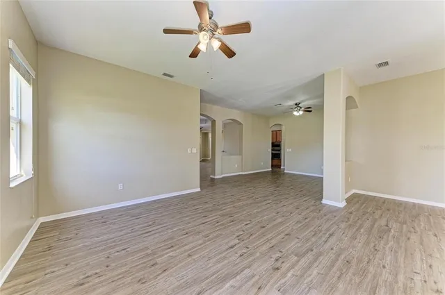 a view of empty room with wooden floor