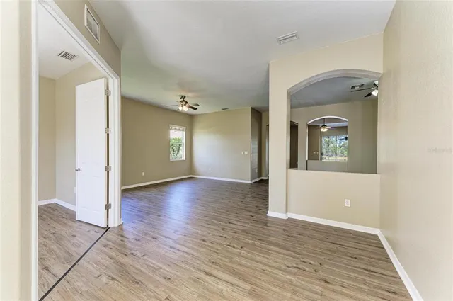a view of a hallway with wooden floor and a living room