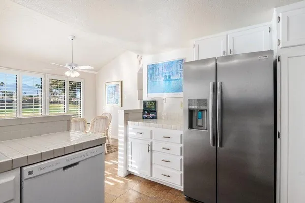 a kitchen with cabinets stainless steel appliances a sink and a window