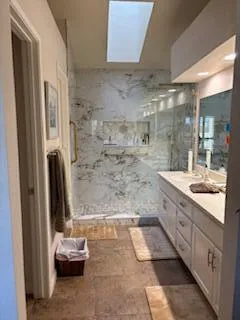 a bathroom with a granite countertop sink a toilet and shower