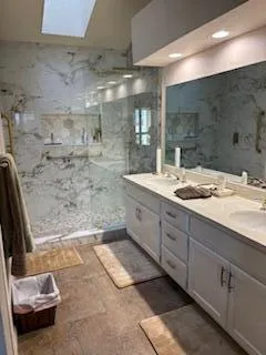 a bathroom with a double vanity sink toilet and shower