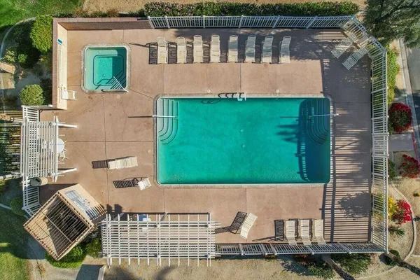 a view of a swimming pool with a patio and a garden