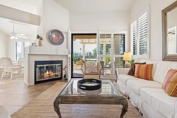 a living room with furniture a large window and a fireplace