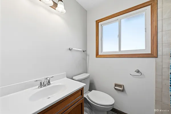 a bathroom with a sink mirror and toilet