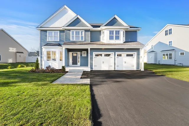 a front view of a house with yard and green space