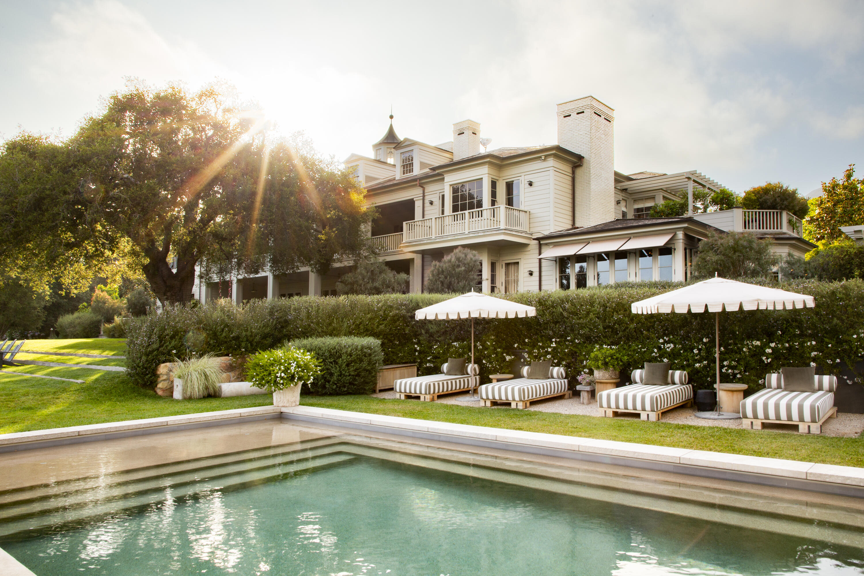 a view of a swimming pool with a lawn chairs under an umbrella
