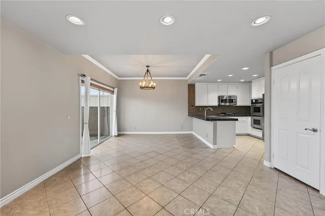 a view of an empty room and kitchen view