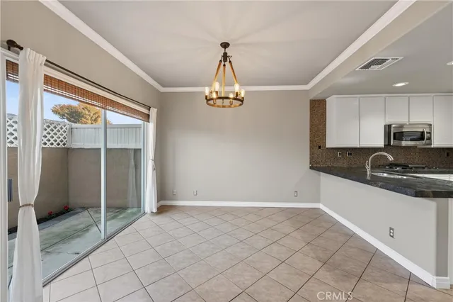 a kitchen with granite countertop white cabinets and refrigerator