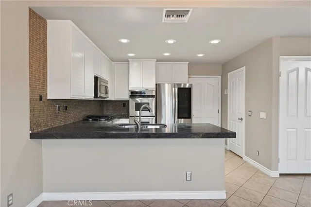 a kitchen with kitchen island granite countertop a sink and refrigerator