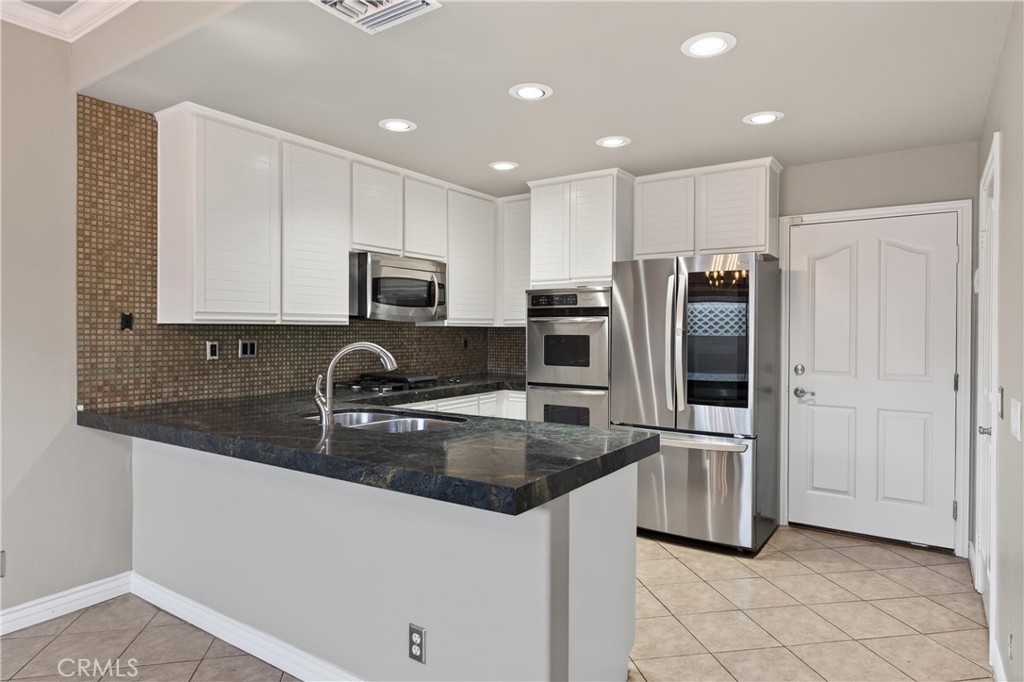 152 Terraza Court Costa Mesa, CA 92627 - Photo 17 of 47 a kitchen with granite countertop a refrigerator and a sink