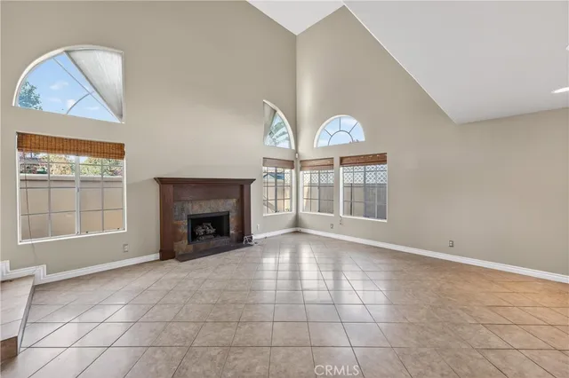 an empty room with windows fireplace and fans