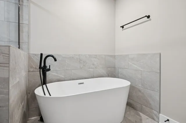 a bathroom with a tub sink shower and mirror