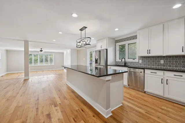 a kitchen with granite countertop wooden floors and white cabinets