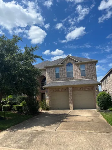 front view of a house with a garden and trees