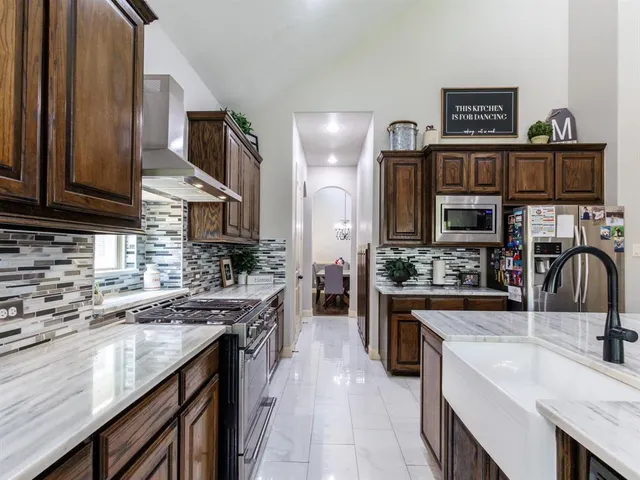 a kitchen with stainless steel appliances granite countertop a sink stove and cabinets