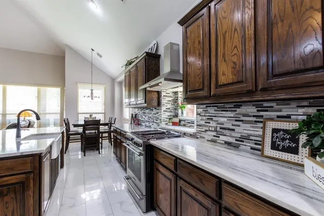 a kitchen with stainless steel appliances granite countertop wooden cabinets a stove top oven a sink and dishwasher