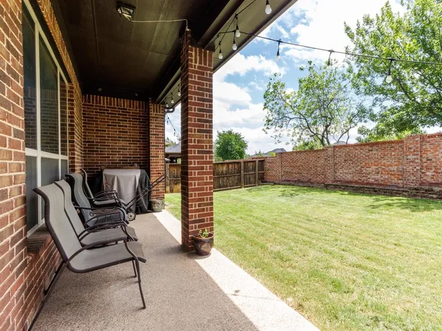 a view of a backyard with chair and wooden fence