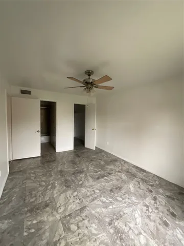 a view of a big room with closet and ceiling fan