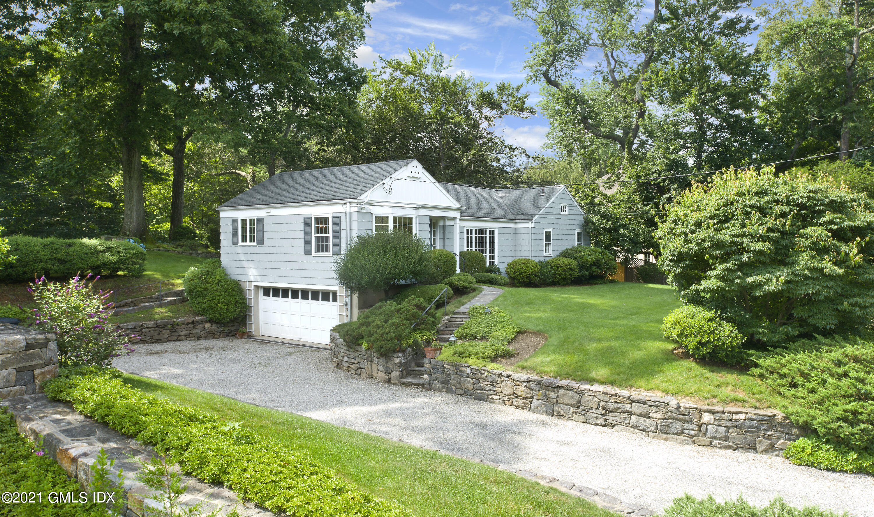 64 Hillside Road Greenwich, CT 06830 - Photo 3 of 24 a front view of a house with a yard and potted plants