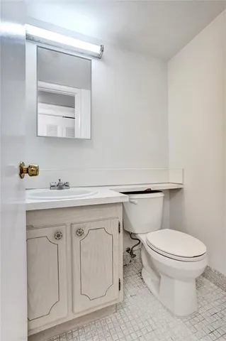 a bathroom with a toilet a sink and mirror