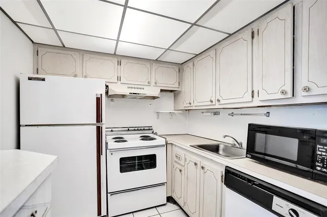 a kitchen with stainless steel appliances white cabinets and white appliances