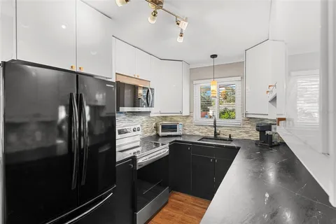 a kitchen with stainless steel appliances a sink stove and refrigerator