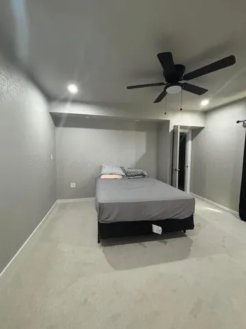 a bedroom with a bed and a ceiling fan