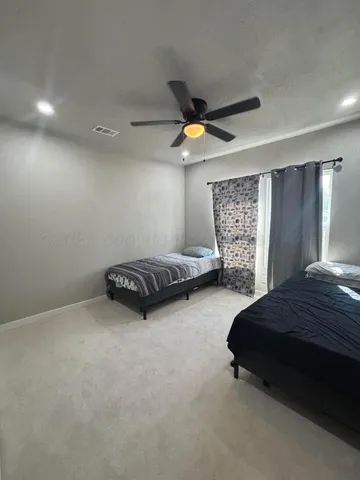 a spacious bedroom with a bed and a chandelier