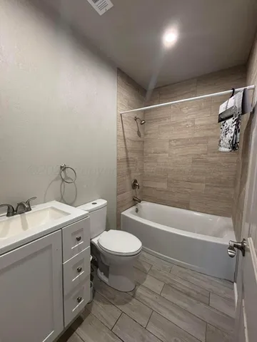a bathroom with a granite countertop sink a toilet and bathtub