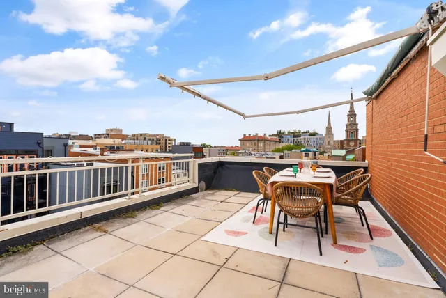 a balcony with table and chairs