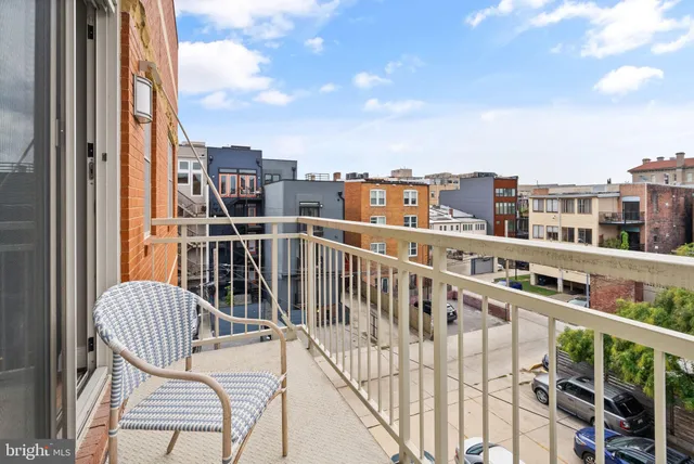 a view of a balcony with wooden chairs