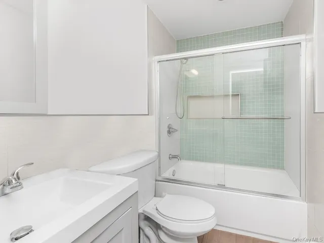 a bathroom with a bathtub shower sink vanity and toilet