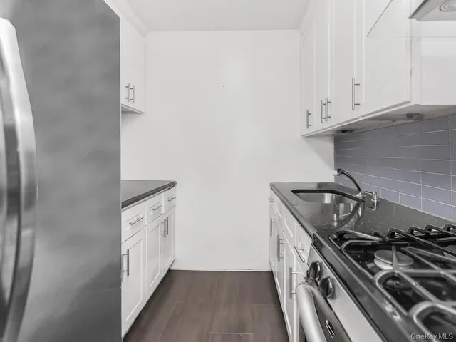 a kitchen with white cabinets and a stove top oven