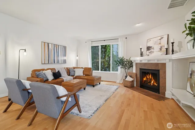 a living room with furniture fireplace and a large window