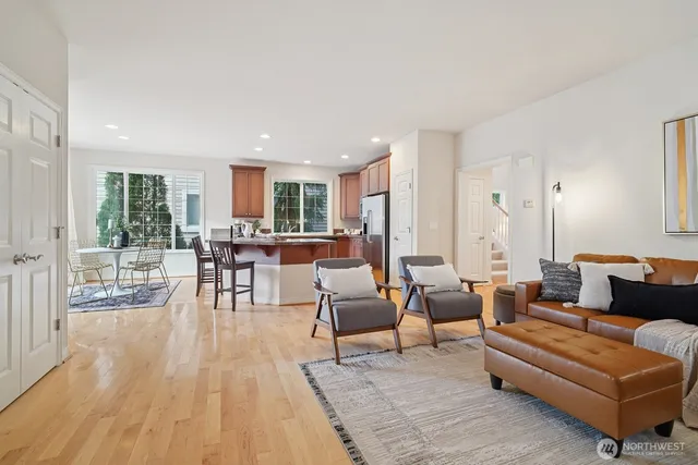 a kitchen with stainless steel appliances granite countertop a stove a sink a refrigerator dining table and chairs