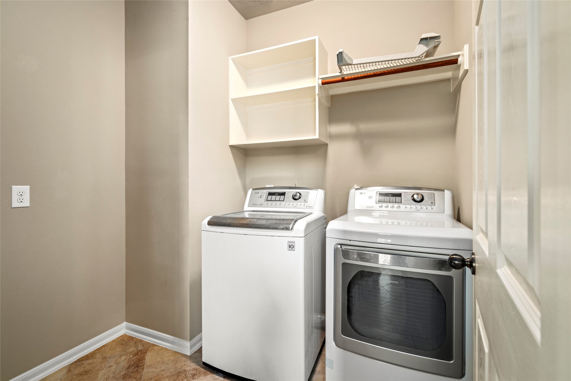 5307 Amber Sky Lane Rosharon, TX 77583 - Photo 29 of 50 A beautifully appointed laundry suite featuring a stainless washer and dryer that remain with the home, plus custom open shelving for effortless organization.