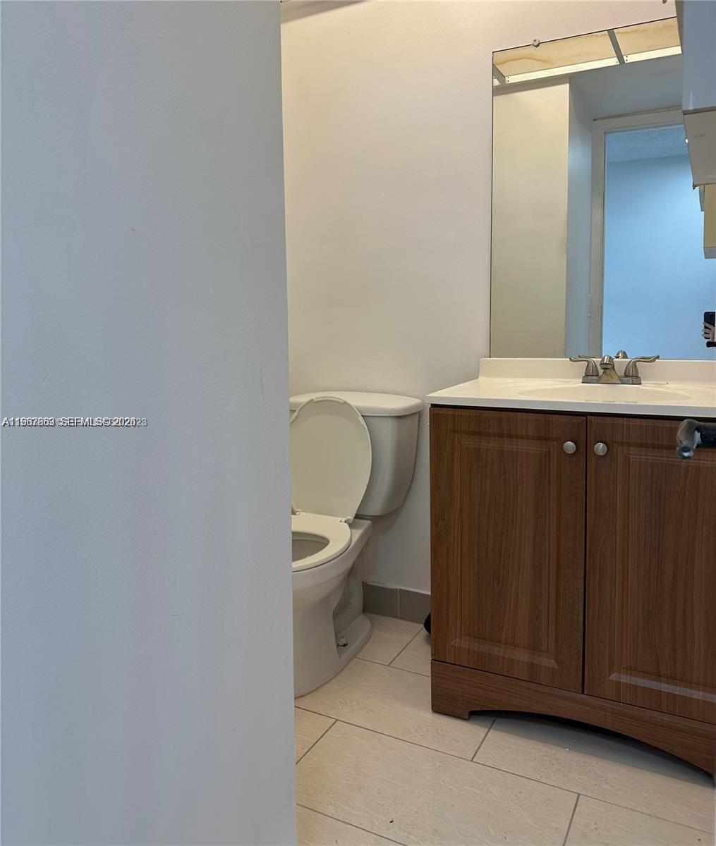 200 Ashbury Road, Unit 209 Hollywood, FL 33024 - Photo 12 of 18 a bathroom with a sink a toilet and mirror