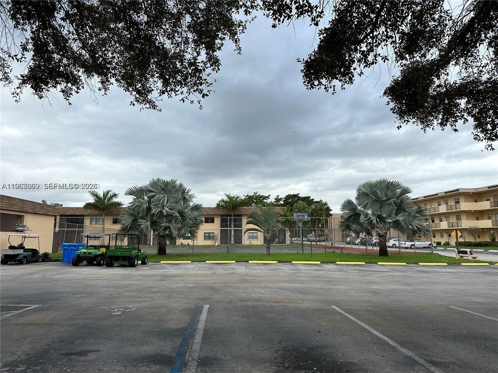 200 Ashbury Road, Unit 209 Hollywood, FL 33024 - Photo 16 of 18 a front view of a house with a yellow lightning and a yard