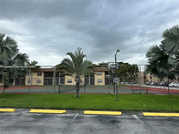 a view of a house with a yard and palm trees