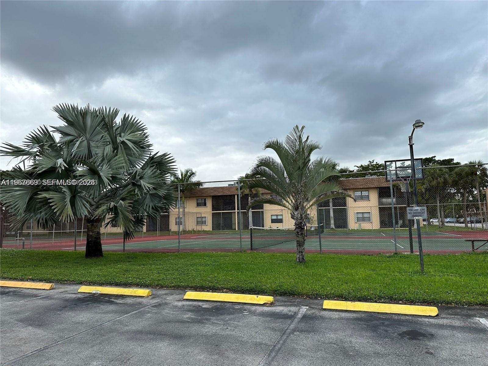 200 Ashbury Road, Unit 209 Hollywood, FL 33024 - Photo 18 of 18 a view of a house with a big yard and palm trees