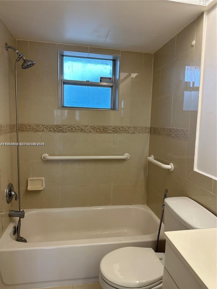 200 Ashbury Road, Unit 209 Hollywood, FL 33024 - Photo 10 of 18 a bathroom with a toilet a sink and bathtub