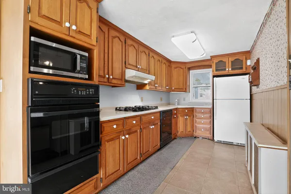 a kitchen with stainless steel appliances granite countertop a refrigerator stove and sink
