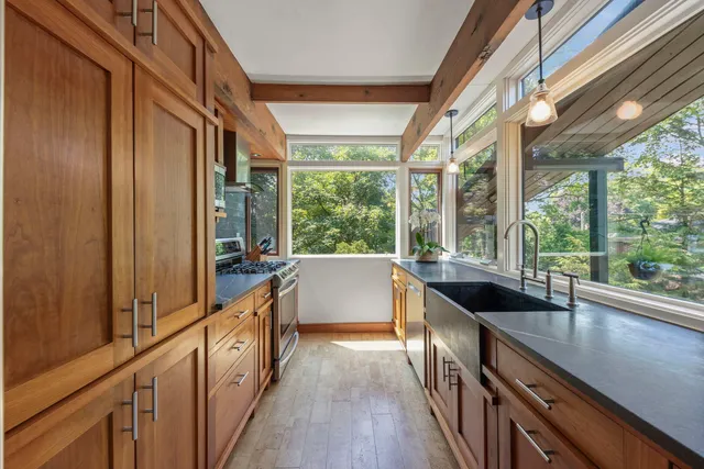 a view of a large kitchen with wooden floor and outdoor space