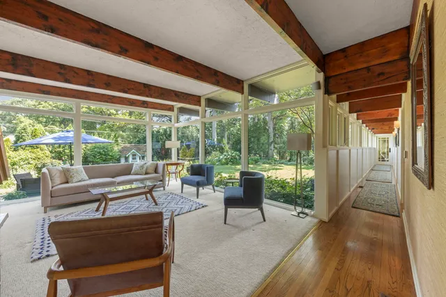 a living room with patio furniture and a floor to ceiling window