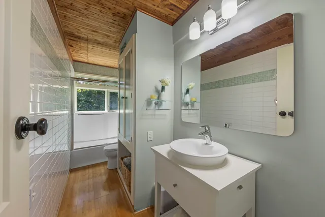 a bathroom with a sink a mirror a vanity and shower