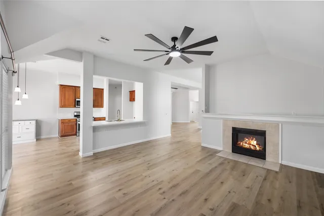 a view of a livingroom with wooden floor and a fireplace