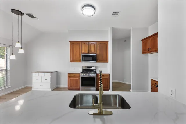 a kitchen with a sink a counter top space appliances and cabinets