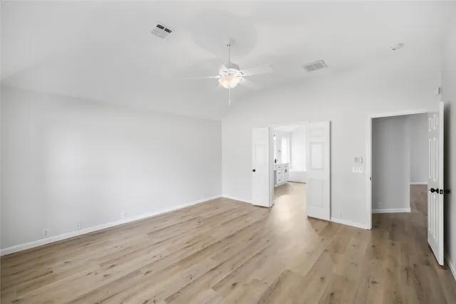 a view of empty room with wooden floor